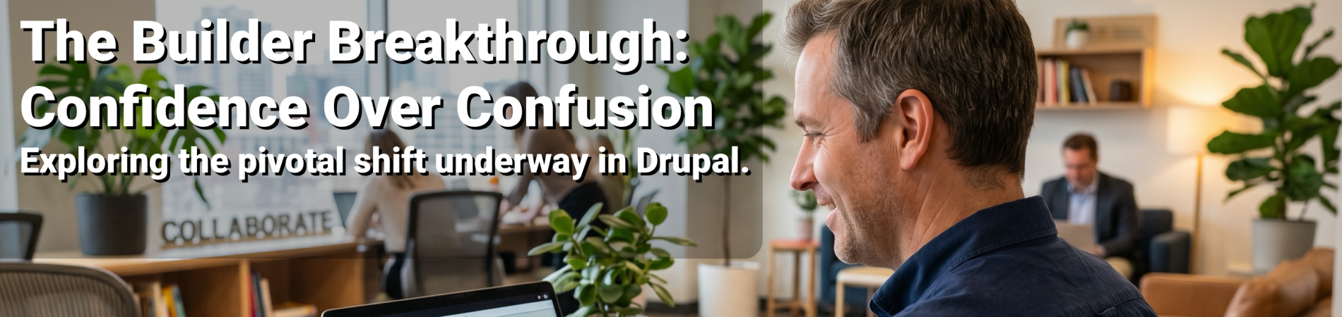 Man working on a laptop at a desk in a modern office, with a plant nearby.